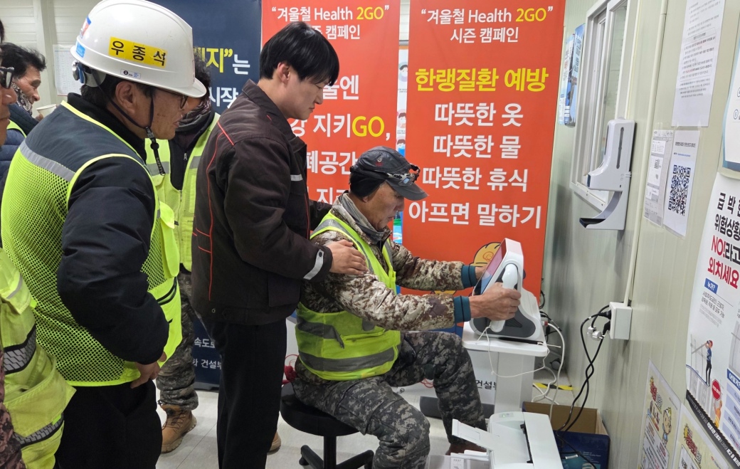 썸넬사진2.+현장+근로자들이+AI기반+스마트+심전도+장비를+사용해+건강+이상징후+여부를+확인해보고+있다..jpg